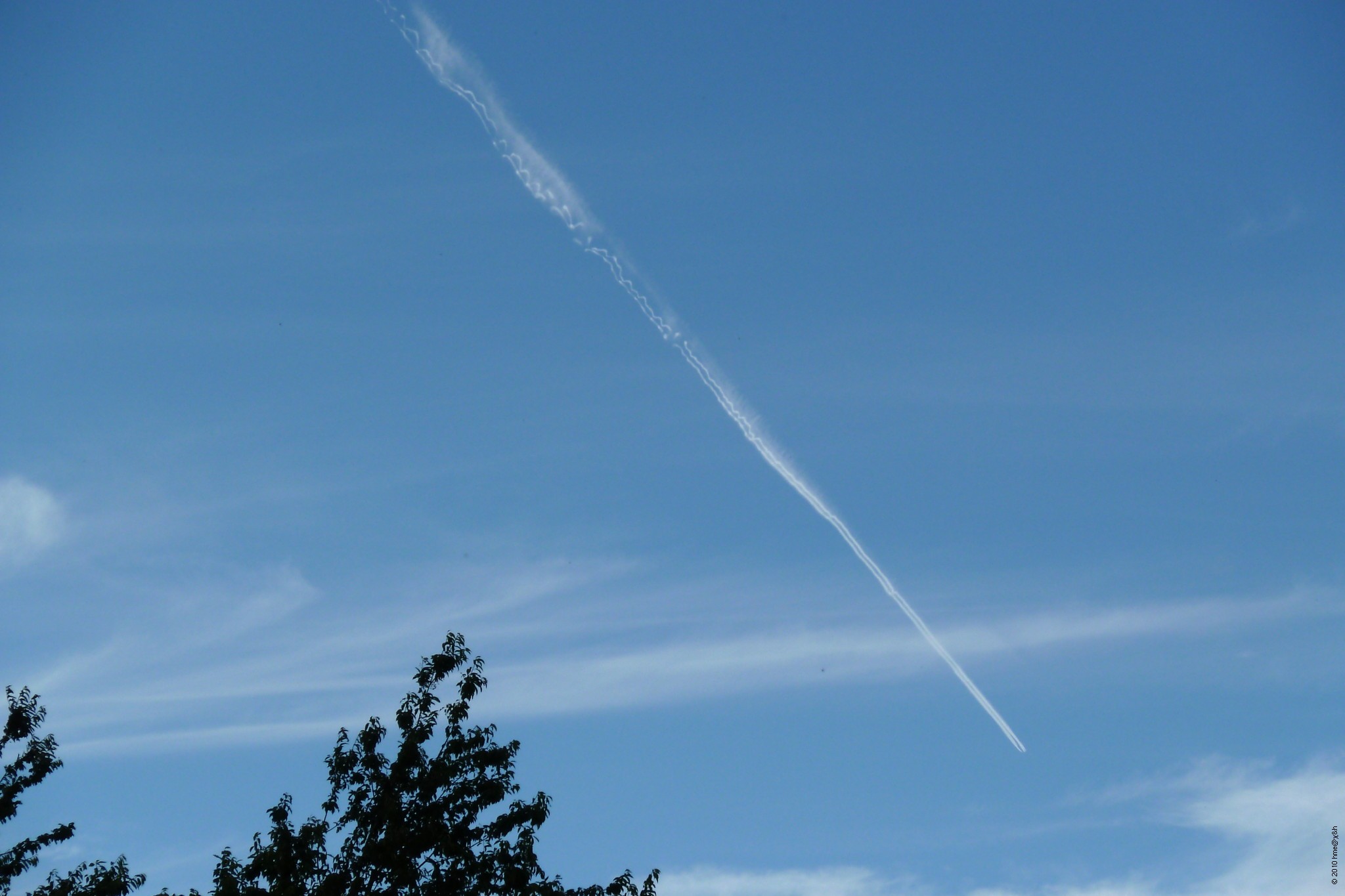 long pair of contrails with wind shear